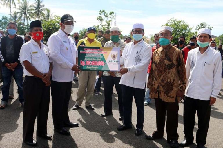 Plt Wali Kota Pariaman, Mardison Mahyuddin didampingi Ketua Baznas Pariaman, Jomohor saat serahkan zakat kepada ratusan tukang ojek dan sopir angkot, Rabu (2/12). (Dok : Istimewa)