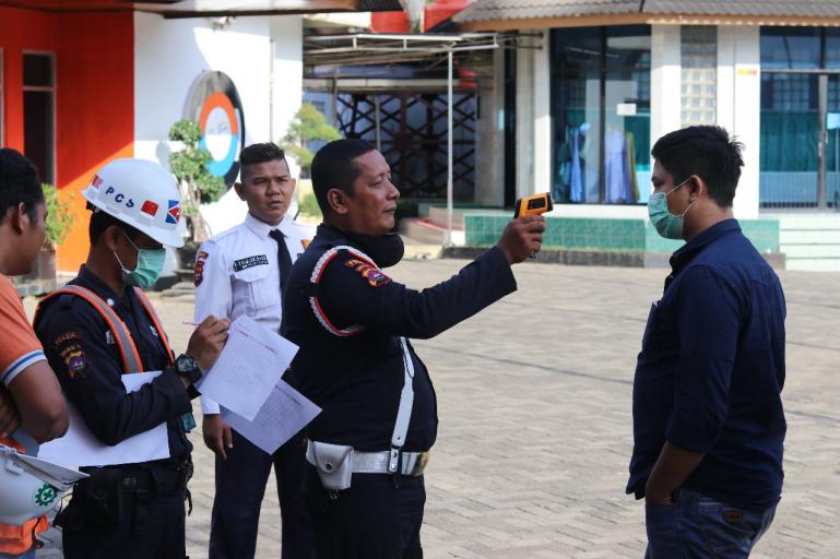 Petugas jaga IPC Teluk Bayur di mengukur suhu tubuh karyawan maupun tamu sebelum memasuki kantor IPC Teluk Bayur, Selasa (17/3). (Foto : Istimewa)