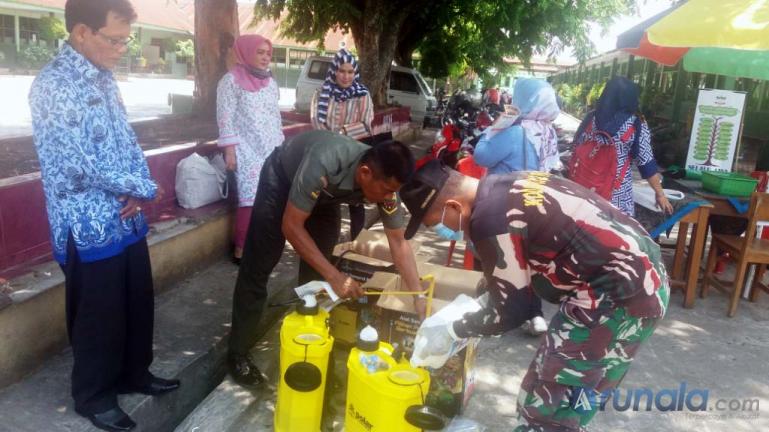 Personel Kodim 0312/Padang didampingi majelis guru siapkan upaya penyemprotan disinfektan di lingkungan sekolah Kartika, Selasa (17/3). (Foto : Dyz)