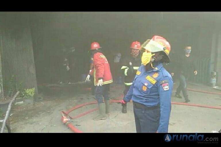 Petugas Damkar Kota Padang sedang memadamkan api yang membakar dua toko di Kompleks Koppas Plaza Padang, Rabu siang (27/5). (Foto : Dyz)