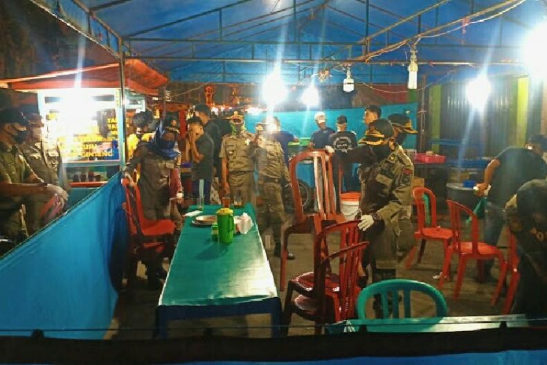 Terlihat tim Satgas gabungan lakukan penertiban pada pedagang yang masih layani konsumen di tempatnya, Sabtu malam (16/5). (Dok : Istimewa)
