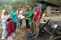 Ketua Tim Media Audy, Nurul Amri bersama Relawan Audy Peduli serahkan bantuan uang tunai kepada Andi, korban kebakaran di Muaro Paneh Kabupaten Solok, Kamis (18/6). (Dok : Istimewa)