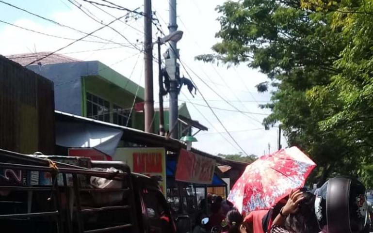 Warga menyaksikan korban tersengat listrik yang masih berada di tiang salah satu tower telekomunikasi di kawasan Jalan Ujung Tanah, Padang, Senin (20/7). (Dok : Istimewa)