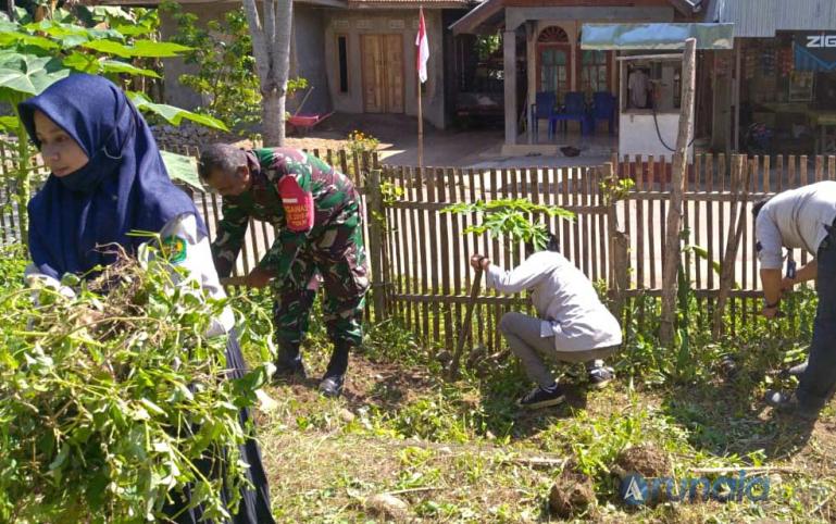 Sertu Ali Darwis bersama mahasiswa bersihkan taman PKK Kampung Padang Panjang I, Kenagarian Kambang Utara, Kamis (20/8). (Foto : Snm)
