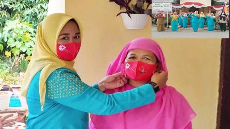 Ketua TP PKK Desa kampung Apar, Ny Risa Dodi Susandra saat membagikan masker kepada salah seorang warga di desa itu, Selasa (25/8/2020) siang. (Dok : Istimewa)