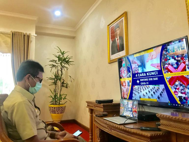 Gubernur Sumbar Irwan Prayitno sedang mendengarkan arahan Mendagri RI Tito Karnavian melalui monitor saat rapat virtual, Senin (10/8). (Dok : Istimewa)