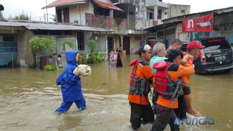 Tim Basarnas saat mengevakuasi warga yang rumahnya terendam banjir di kawasan Jundul Rawang, Kecamatan Padang Selatan, Kamis pagi (10/9). (Foto : Dyz)