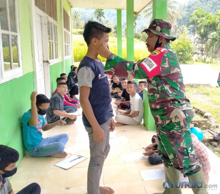 Wadan Satgas TMMD ke-109, Mayor Inf Syawal bagikan masker pada seorang siswaMadrasah Tsanawiyah Swasta Nagari Pancuang Taba, Pessel, Selasa (29/9). (Foto : Rio)
