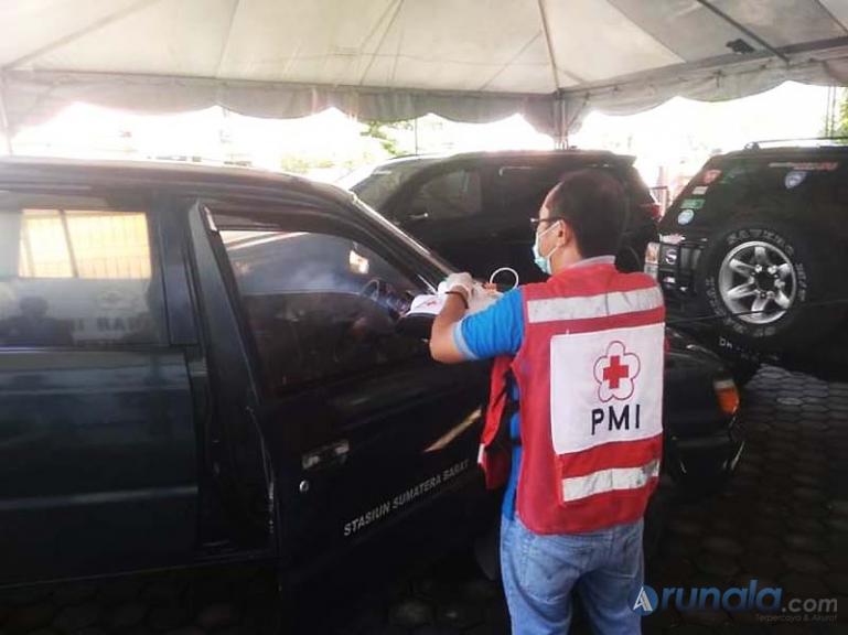 Petugas PMI Sumbar melakukan penyemprotan desinfektan pada salah satu mobil, Selasa (22/9). (Foto : Dyz)