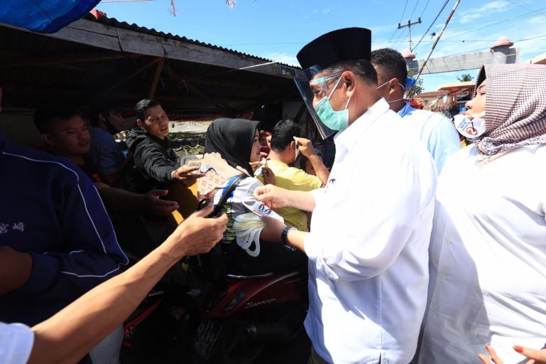 Cagub Sumbar Nasrul Abit saat bagikan masker kepada pencukungnya saat di Pasar Kota Payakumbuh, Jumat (16/10). (Dok : Istimewa)