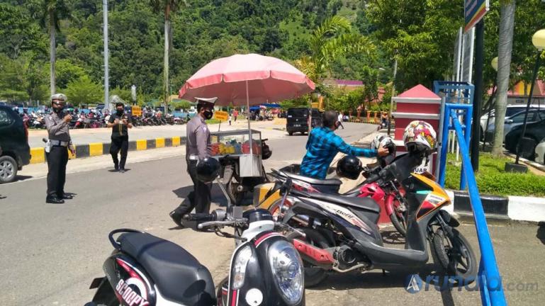 Sat Lantas Polres Pessel saat menertibkan sejumlah ranmor yang parker di bahu jalan di sekitar RSUD M Zein Painan, Selasa siang (20/10). (Foto : Rio)