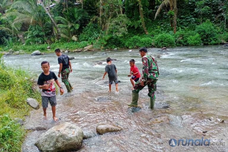 Sejumlah anak-anak di Nagari Pancuang Taba terlihat antusias membantu personel TNI mengumpulkan batu untuk pembuatan Tugu TMMD di nagari mereka, Jumat (16/10). (Foto : Rio)
