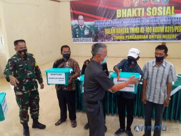 Pj Bupati Pessel Mardi disaksikan Komandan Pusat Teritorial Angkatan Darat (Danpusterad) Letnan Jenderal TNI R Wisnoe Prasetja Boedi serahkan bantuan kepada warga yang berpartisipasi dalam TMMD ke-109 di Pessel. Kamis (15/10). (Foto : Rio)