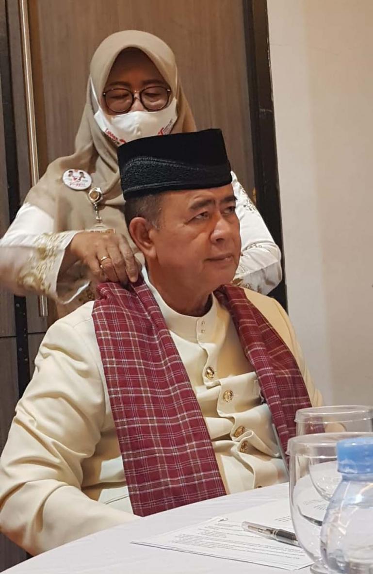 Ny wartawati saat membetulkan letak kain sarung yang ada dipundak suaminya Nasrul Abit yang menjadi Cagub Sumbar sebelum ikut debat paslon putaran 2, Kamis (3/12). (Dok : Istimewa)