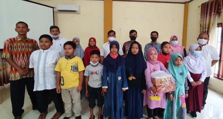 Kades Cimparuah, Maifialdi, Berfoto Bersama Dengan Anak-Anak Yang Menerima Bantuan Seperangkat Peralatan Sekolah, Rabu (30/12). (Dok : Istimewa)