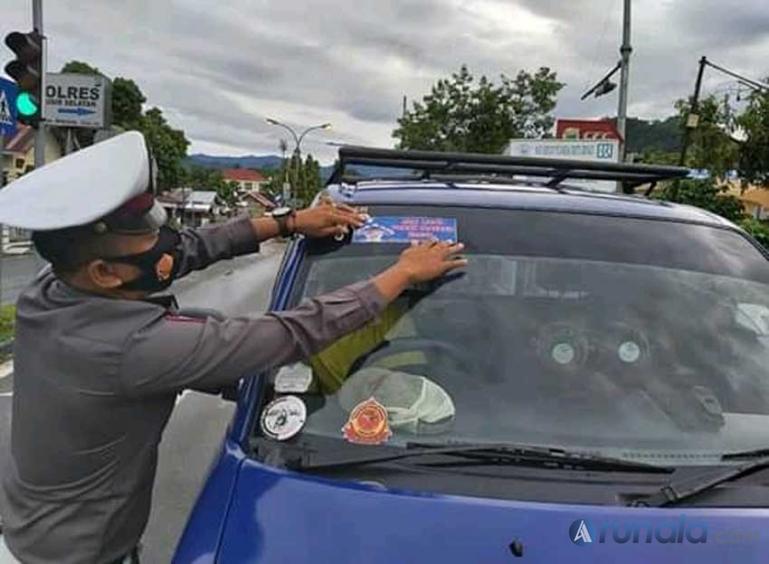 Seorang personel Satlantas Polres Pessel memasangkan stiker 