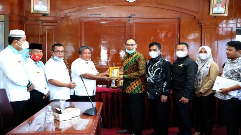 Asisten II Setko Pariaman, Sumiramis saling tukar cindermata dengan Ketua Pansus Kabupaten Kutai Kertanegara, Ahmad Zulfiansyah saat berkunjung ke Kota Pariaman, Rabu siang (10/2). (Dok : Istimewa)