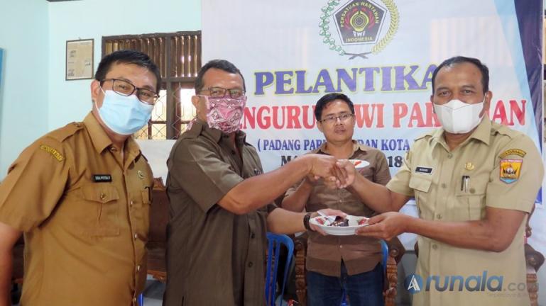 Kepala Dinas Kominfo Pariaman, Hendri membawakan kue ke kantor PWI Pariaman di saat peringatan Hari Pers. Selasa (9/2). (Foto : Arzil)