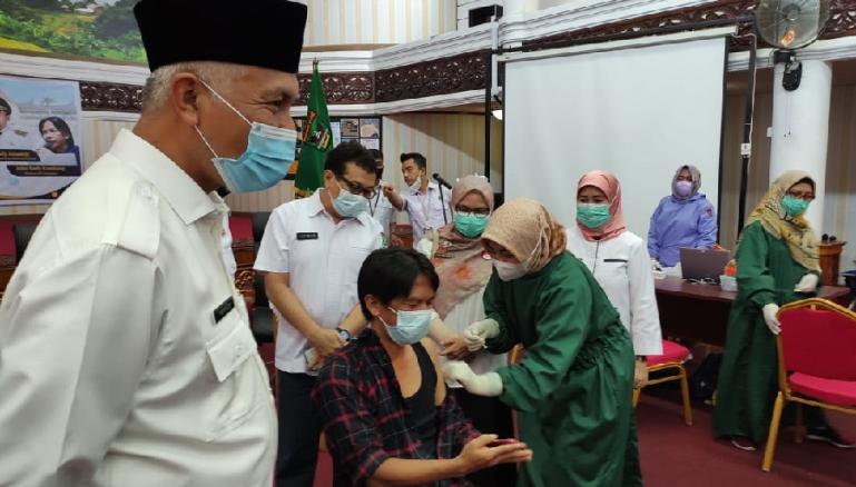 Gubernur Mahyeldi menyaksikan Ketua IJTI Sumbar John Kambang saat jalani vaksinasi Covid-19 di aula kantor gubernur, Rabu (10/3). (Dok : Istimewa)
