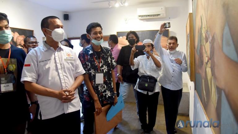 Wali Kota Genius Umar saat menyaksikan lukisan hasil karya pelukis Hamdi Mubarak di Kopi Dent di Kampung Perak, Pariaman, Jumat sore (26/3). (Foto : Arzil)