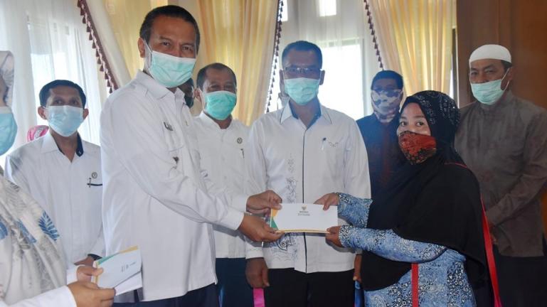 Wako Genius serahkan bantuan Baznas Pariaman kepada delapan warga untuk program bedah rumah, Rabu (17/3). (Dok : Istimewa)