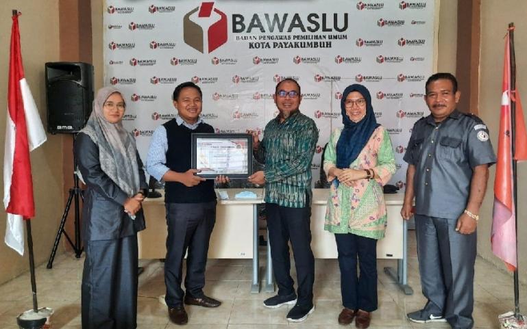 Wakil Ketua KI Sumbar, Arif Yumardi saat menerima cinderamata dari Ketua Bawaslu Kota Payakumbuh, M Khadafi, Senin (19/4). (Dok : Istimewa)