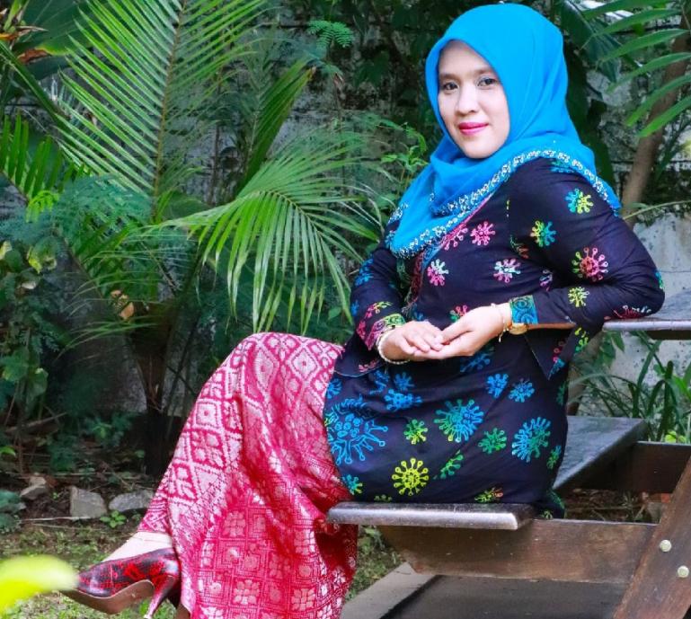 Komisioner KI Sumbar, Tanti Endang Lestari menyempatkan diri menjadi model untuk busana Batik bermotif virus corona hasil kreasi Dewi Busana Lunang. (Dok : Istimewa)