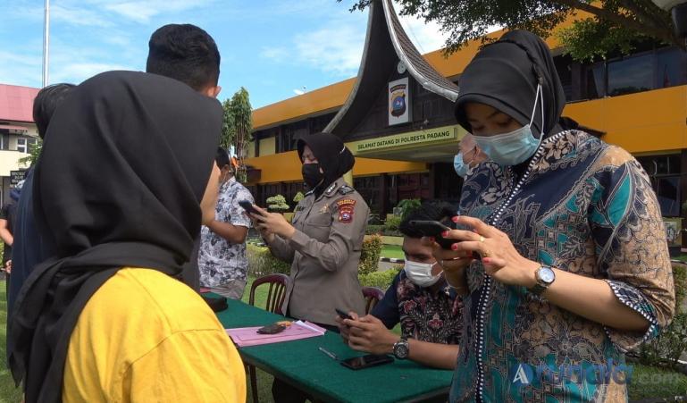 Masyarakat yang terkena razia Perda AKB karena tidak pakai masker saat aktivitas di luar rumah sedang didata petugas di Mapolresta Padang, Jumat (23/4). (Foto : Derizon)