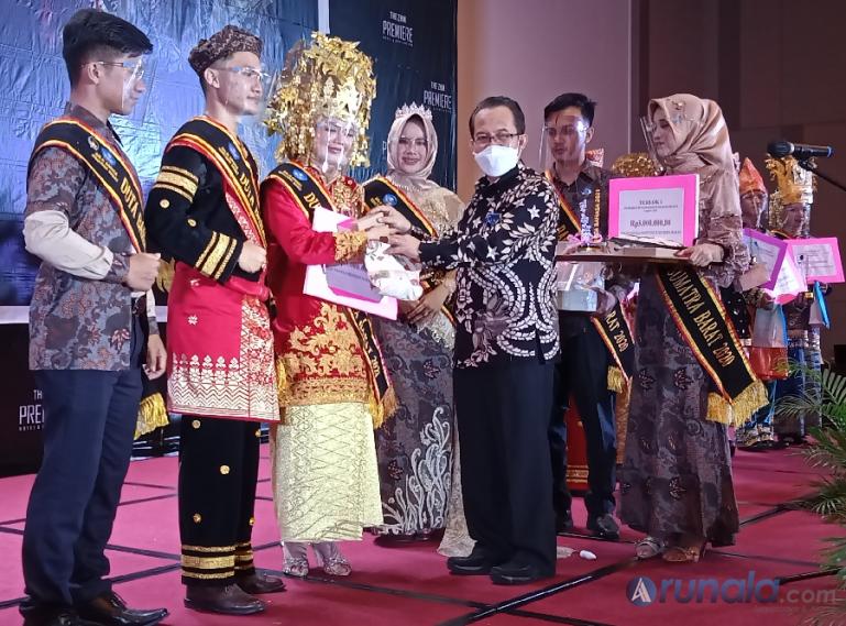 Kepala Pusat Pembinaan Bahasa dan Sastra, Dr Abdul Khak ssat memberikan penghargaan kepada para juara pertama Uda dan Uni Duta Bahasa Sumbar 2021, Jumat malam (28/5). (Foto : Arzil)