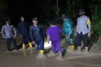 Kapolsek Tapan, Iptu Gusmanto bersama jajarannya dan perangkat kecamatan meninjau lokasi banjir yang terjadi di dua nagari di Tapan, Minggu malam (16/5). (Dok : Istimewa)