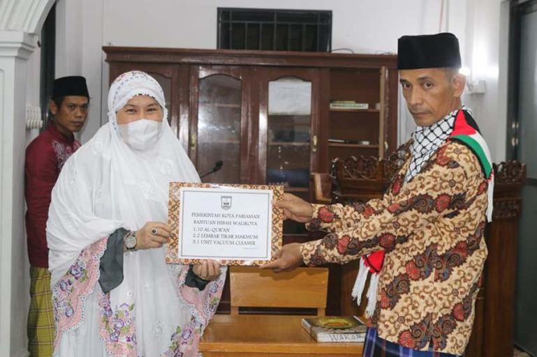 Ketua Tim 3 Safari Ramadhan Pemko Pariaman, Fitri Nora menyerahkan donator kepada pengurus Mesjid Darul Muttaqin Desa Koto Maparak, Rabu (21/4). (Dok : Istimewa)