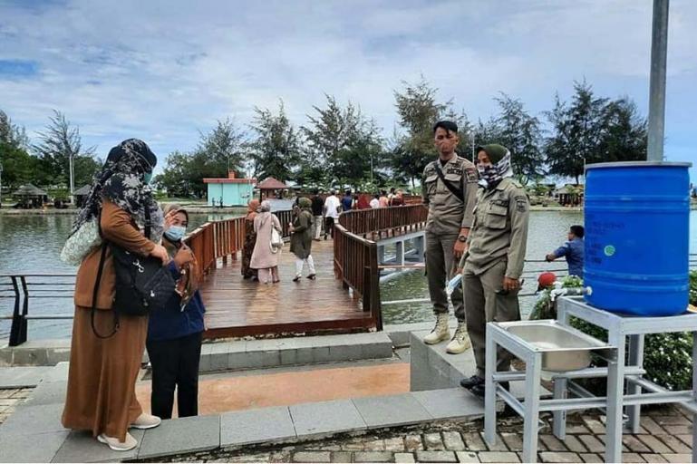 Petugas Sat Pol PP Kota Pariaman lakukan pengawasan Prokes di salah satu tempat wisata di Kota Pariaman, Sabtu (15/5). (Dok : Istimewa)