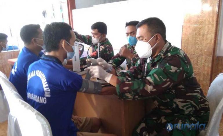Warga binaan Lapas Klas II/A Padang jalani pemeriksaan sebelum divaksin petugas medis dari Kodim 0312/Kota Padang di Lapas Padang, Sabtu (26/6). (Foto : Derizon)