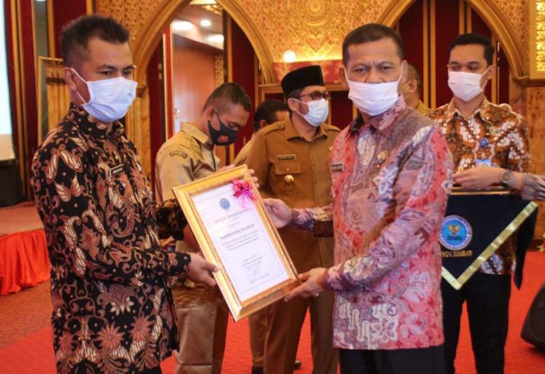 Kepala BNNP Sumbar, Brigjen Pol Khasril Arifin menyerahkan penghargaan kepada pihak yang berkontribusi menekan peredaran narkoba dilingkungannya, Senin (28/6). (Dok : Istimewa)