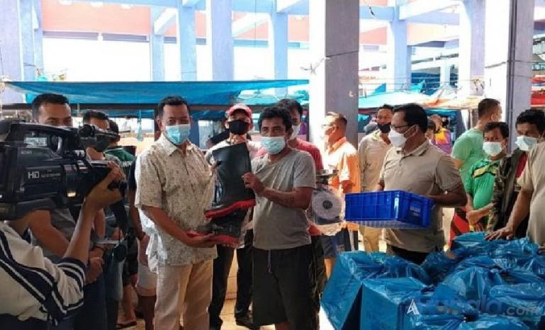 Bupati Rusma Yul Anwar saat serahkan bantuan untuk pedagang ikan di Pasar Inpres Painan, Sabtu siang (17/7). (Foto : SNM)