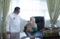 Afridawati diberi penghargaan untuk duduk di kursi kerja bupati yang didampingi Eka Putra yang berdiri di sampingnya, Jumat (9/7). (Dok : Istimewa)