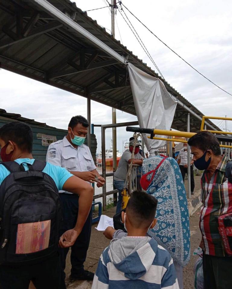 Petugas pintu masuk kapal penyeberangan memeriksa dokumen hasil rapid test atau antigen calon penumpang di pelabuhan Bungus Padang, Selasa siang (13/7). (Dok : Istimewa)