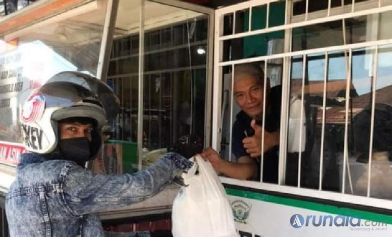 Seorang pasien Covid yang kurang mampu menerima makanan gratis dari Raja Corner saat jalani isolasi mandiri, Sabtu (17/7). (Foto : Derizon)