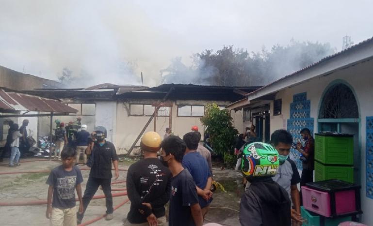 Sejumlah warga menyaksikan kepulan asap yang ada di gudang milik Dinas Pertanian Sumbar yang terbakar Kamis siang (5/8). (Dok : Istimewa)