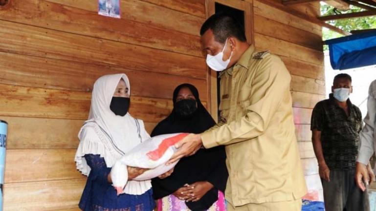 Salah seorang pemilik rumah yang terkena puting beliung terima bantuan dari Wako Pariaman, Genius Umar, Senin (2/8). (Dok : Istimewa)