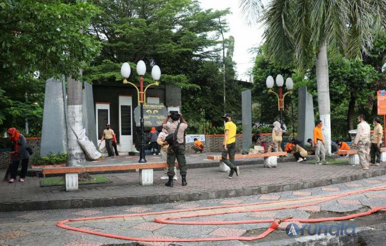 Petugas BPBD Kota Padang bersama relawan membersihkan Tugu Gempa 30 September, Selasa (28/9). (Foto : Derizon)