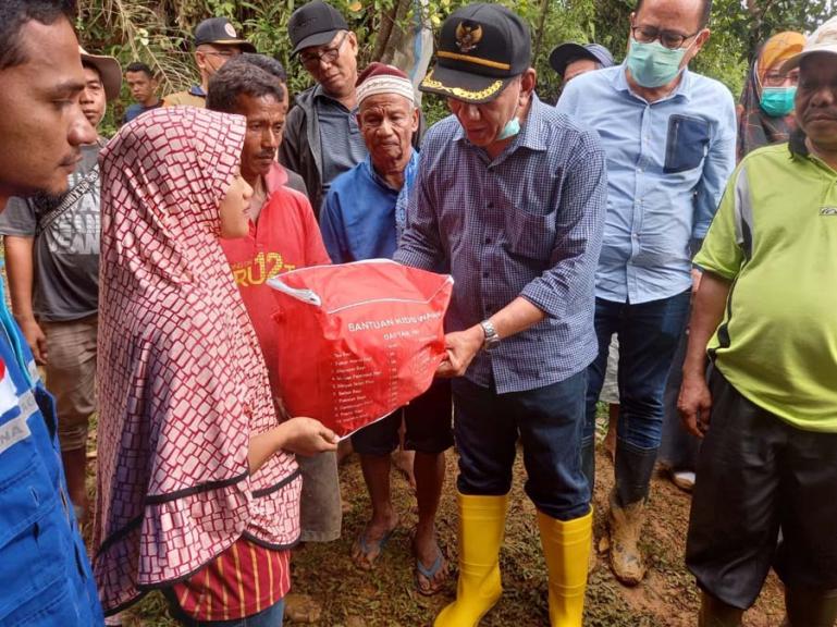Bupati Pessel, Rusma Yul Anwar ketika menyerahkan bantuan kepada salah seorang pemilik rumah yang rusak akibat longsor, Minggu (19/9). (Dok : Istimewa)
