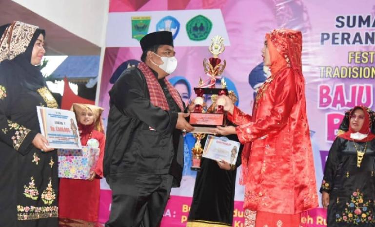Bupati Padangpariaman, Suhatri Bur serahkan piala kepada pemenang lomba baju kuruang basiba, di TMII Jakarta, Sabtu malam (20/11). (Dok : Istimewa)