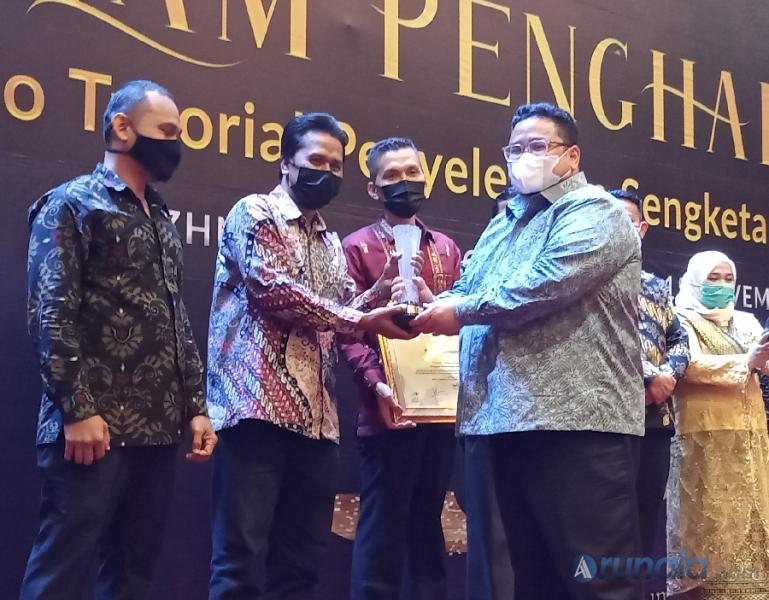 Anggota Bawaslu RI, Rahmat Bagja saat serahkan piala pemenang  kategori video penerimaan permohonan sengketa kepada Bawaslu Kabupaten Sijunjung, Senin malam (15/11). (Foto : Arzil)