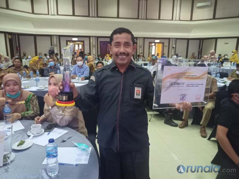Ketua Bawaslu Sumbar, Surya Efitrimen menunjukkan piala dan sertifikat peringkat 1 Anugerah KIP 2021 dari KI Sumbar, Senin (6/12). (Foto : Arzil)