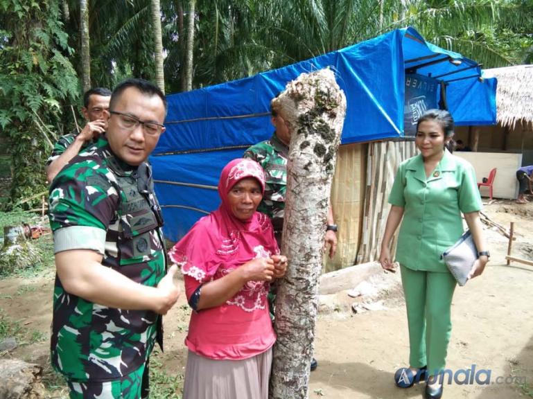 Dandim 0311/Pessel Letkol Inf Moch Suherli bersama istri saat menemui Evi dengan latar belakang gubuk terpalnya, Sabtu (12/12). (Foto :SNM)
