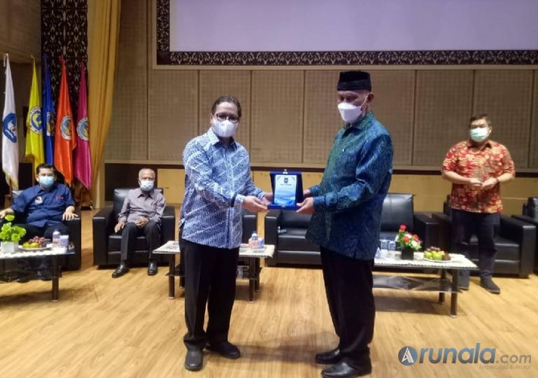 Ketua POGI Sumbar, Dr dr Dovy Djanas SpOG KFM menyerahkan cinderamata kepada Gubernur Sumbar Mahyeldi Ansharullah saat Gebyar Vaksinasi Ibu Hamil dan Menyusui di Auditorium UNP, Sabtu (4/12). (Foto : Fajril)