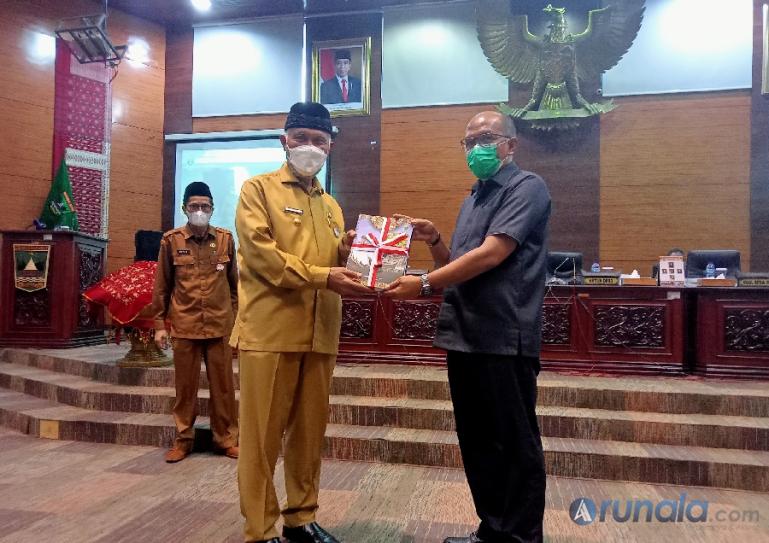 Ketua DPRD Sumbar, Supardi saat menerima buku nota penyampaian LKPJ 2021 dari Gubernur Mahyeldi seusai rapat paripurna, Senin (21/2). (Foto : Arzil)