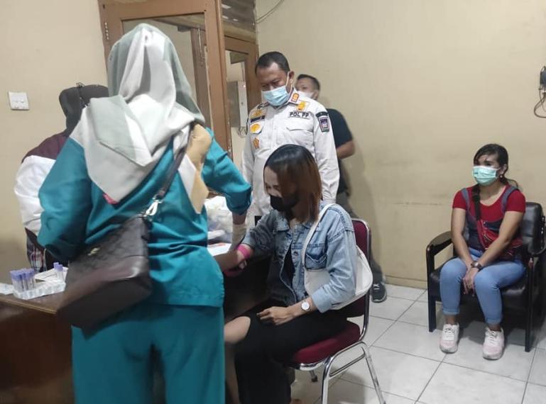 Kasat Pol PP Kota Padang, Mursalim menyaksikan anggotanya mendata pemandu lagu yang diamankan setelah razia, Rabu (2/3) dini hari. (Dok : Istimewa)