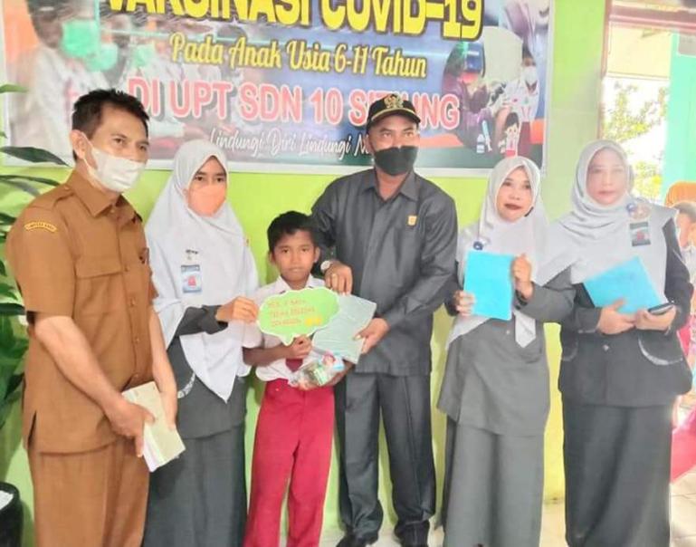 Ketua DPRD Dharmasraya, Pariyanto berikan bingkisan pada murid seusai divaksin, di SDN 10 Sitiung, Selasa (8/3). (Dok : Istimewa)